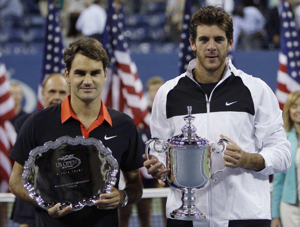 Roger Federer, left, of Switzerland, and Juan Martin del Potro, of Argentina, pose with their trophies following the men's finals championship at the U.S. Open tennis tournament in New York, Mond ...