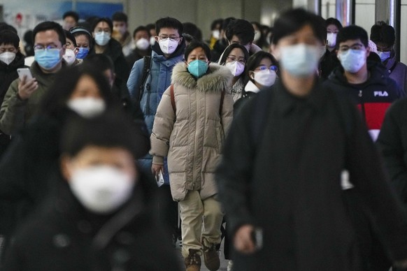 FILE - Masked commuters walk through a walkway between two subway stations as they make their way to work during the morning rush hour in Beijing on December 1.  20, 2022. Japanese Prime Minister Fumio Kishida announces…