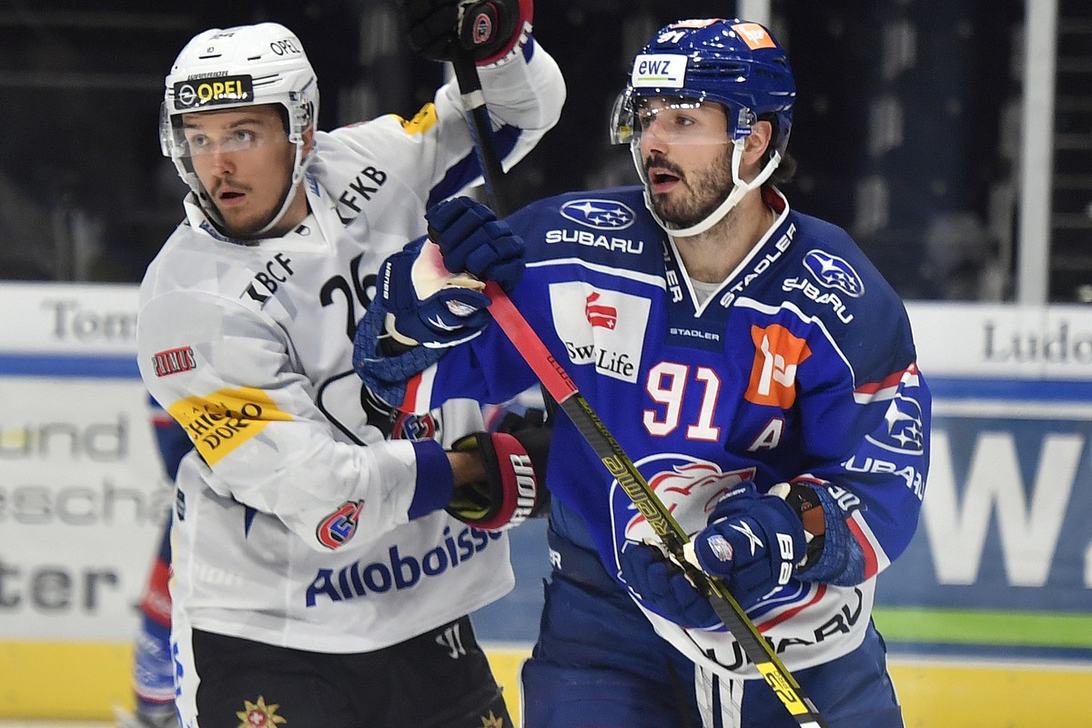 Der Zuercher Denis Hollenstein, rechts, unn der Fribourger David Aebischer, links, beim Eishockeyspiel der National League ZSC Lions gegen den HC Fribourg Gotteron im Hallenstadion in Zuerich am Freit ...