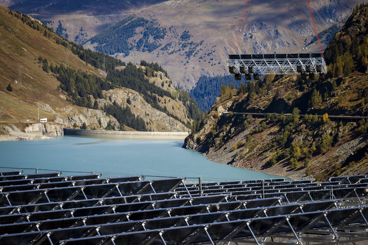 ARCHIVBILD ZUM WATT D'OR --- A floating barge with solar panels is lifted by a helicopter towards the &amp;quot;Lac des Toules&amp;quot;, an alpine reservoir lake, in Bourg-Saint-Pierre, Switzerl ...