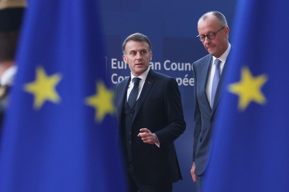 Germany's Chancellor Friedrich Merz, right, and French President Emmanuel Macron walk together as they arrive for the EU summit at the European Council building in Brussels, Thursday, March 19, 2 ...