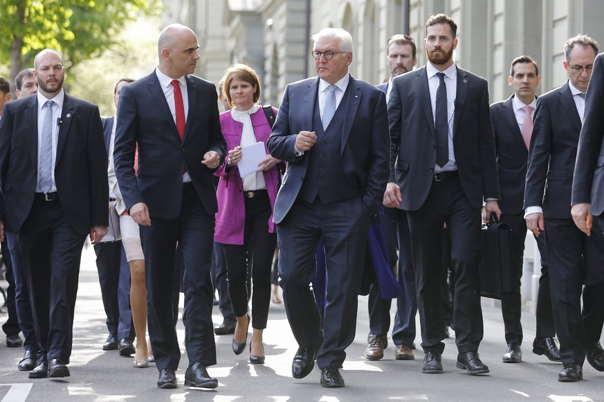 epa06692297 German President Frank-Walter Steinmeier (C-R) and Swiss Federal President Alain Berset (C-L), center left, discuss on their way to a press conference, during Steinmeier&#039;s two days st ...