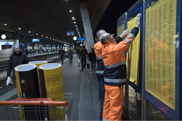 SBB-Mitarbeiter wechseln einen Fahrplan aus, aufgenommen am Samstag, 10. Dezember 2016, im Hauptbahnhof Zuerich. Der diesjaehrige Fahrplanwechsel der SBB wird am Sonntag, 11. Dezember 2016, vollzogen  ...