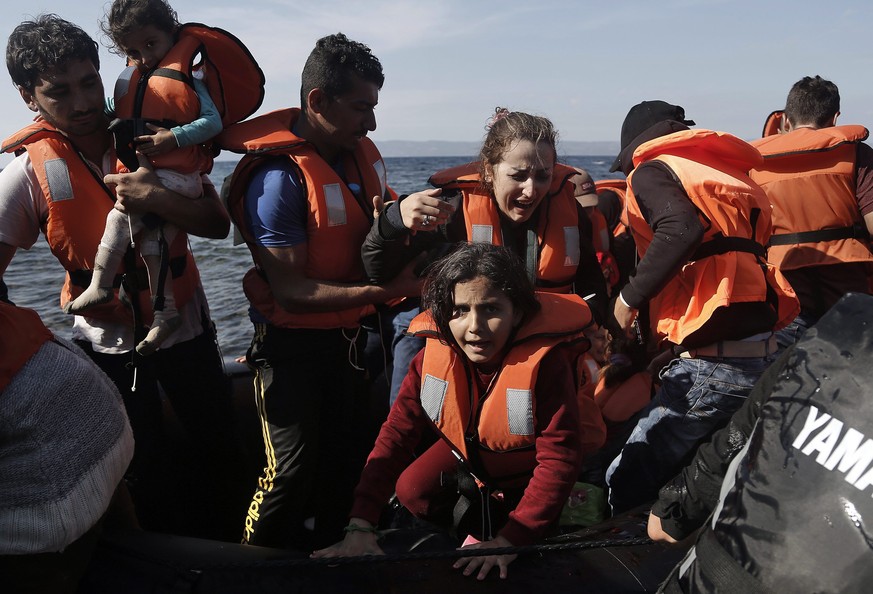 epa04970608 Syrian refugees react upon their arrival in an overloaded rubber dinghy from Turkey on the Greek island of Lesvos, after having crossed the Aegean Sea, Greece, 09 October 2015. A recently  ...