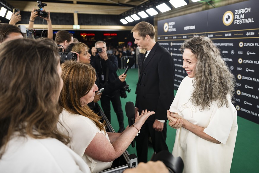 epa13269509 British actor Olivia Colman (R) and Swedish actor and director Alexander Skarsgard (C) arrive on the Green Carpet during the 22nd Zurich Film Festival (ZFF) in Zurich, Switzerland, 28 Sept ...