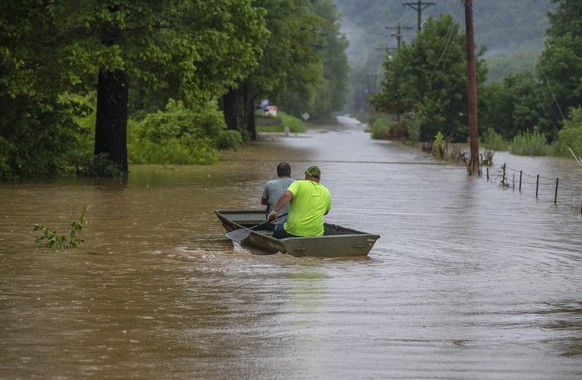 Men ride in a bpsy along flooded Wolverine Road in Breathitt County, Ky., on Thursday, July 28, 2022. Heavy rains have caused flash flooding and mudslides as storms pound parts of central Appalachia.  ...