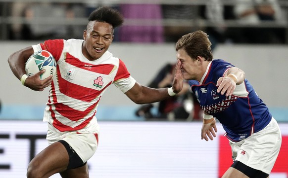 Japan's Kotaro Matsushima, left, fends off Russia's Vladislav Sozonov to score his third try during the Rugby World Cup Pool A game at Tokyo Stadium between Russia and Japan in Tokyo, Japan, ...