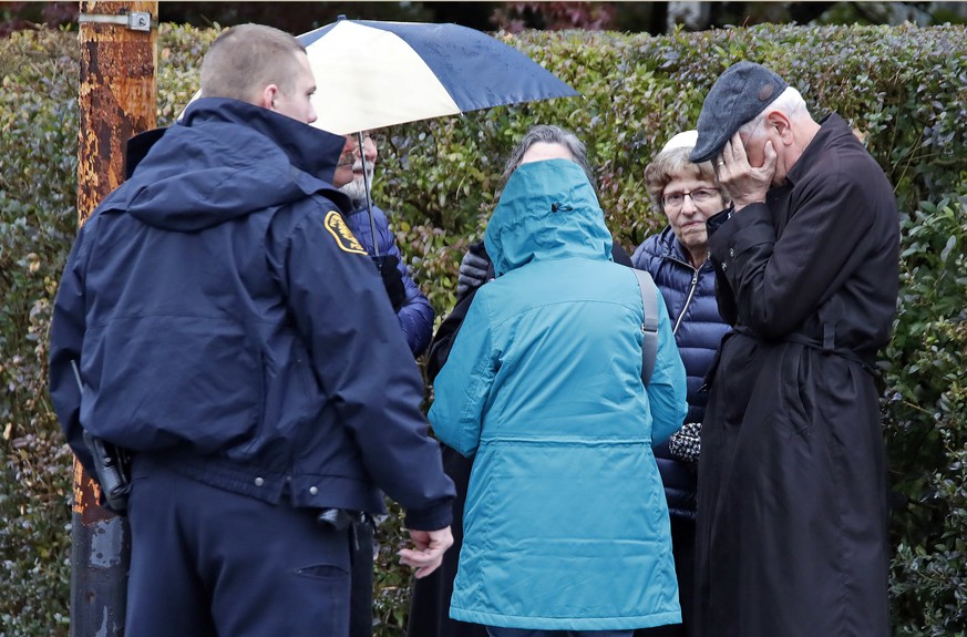 People gather on a corner near the Tree of Life Synagogue in Pittsburgh, Pa., where a shooter opened fire Saturday, Oct. 27, 2018, injuring multiple people. (AP Photo/Gene J. Puskar)