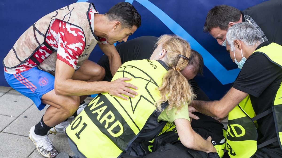 epa09468032 Manchester's Cristiano Ronaldo (L) and match stewards attend to a steward who got hit by a shot of Ronaldo during the warm up ahead of the UEFA Champions League group F soccer match b ...
