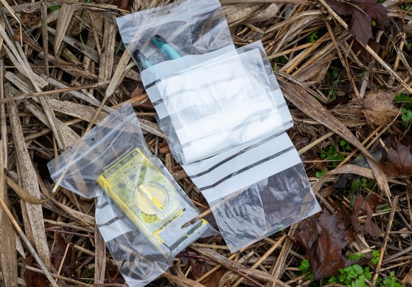 06.12.2022, Bayern, Manching: Diverse von Polizietauchern im Pichler Weiher, nahe dem Keltenmuseum, gefundene Gegenst�nde liegen am Ufer in Plastikbeuteln. Die Suchaktion fand im Lauf der Ermittlungen ...