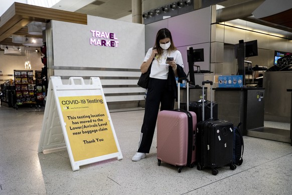 epa09888829 A passenger wearing a mask waits at the Covid-19 testing site at the International flights terminal of the Los Angeles Airport, in Los Angeles, California, USA, 13 April 2022. The Centers  ...