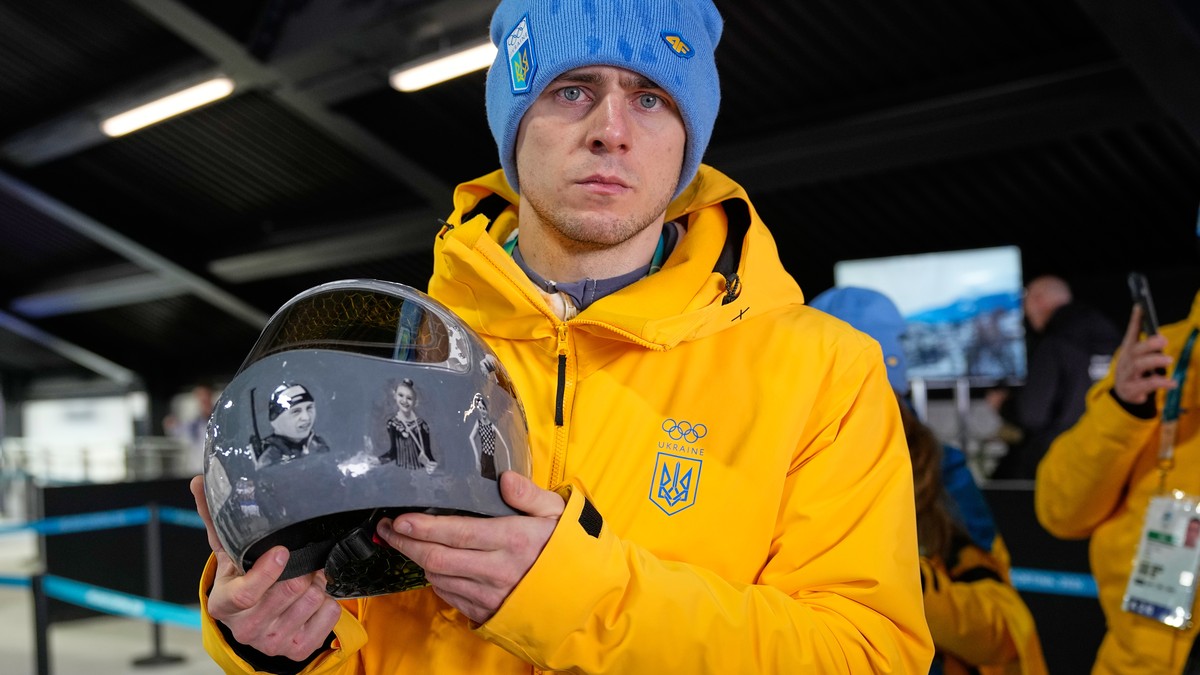 Ukrainian skeleton athlete Vladyslav Heraskevych holds his crash helmet as he stands in the mixed zone of the sliding center at the 2026 Winter Olympics, in Cortina d'Ampezzo, Italy, Thursday, Fe ...