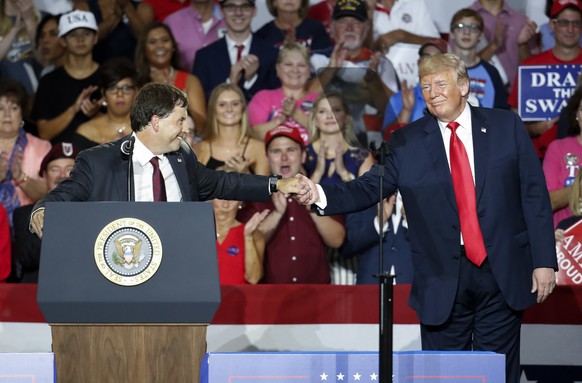 President Donald Trump, right, shakes hands with 12th Congressional District Republican candidate Troy Balderson, left, during a rally, Saturday, Aug. 4, 2018, in Lewis Center, Ohio. (AP Photo/John Mi ...