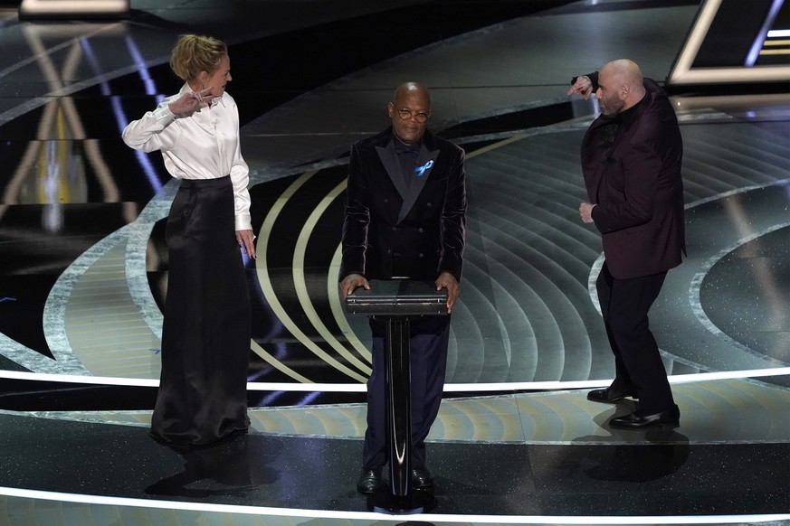 Uma Thurman, from left, Samuel L. Jackson and John Travolta present the award for best performance by an actor in a leading role at the Oscars on Sunday, March 27, 2022, at the Dolby Theatre in Los An ...