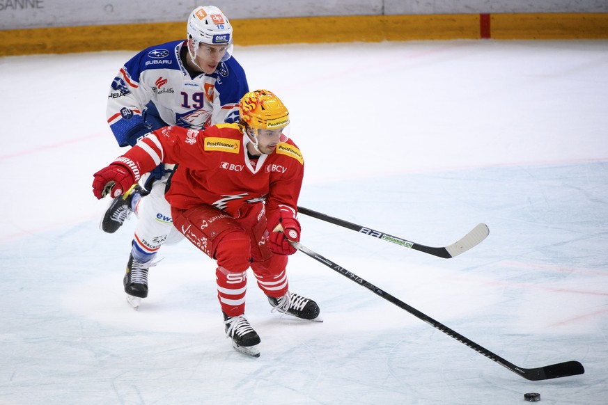 L&#039;attaquant zuerichois Reto Schaeppi, gauche, lutte pour le puck avec le top scorer PostFinance lausannois Denis Malgin, droite, lors du 1er match de quart de finale playoff a huis clos du champi ...