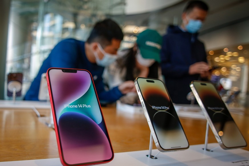 epa10283017 People look at i-Phone 14 models at an Apple store at a mall in Beijing, China, 03 November 2022. Around 600,000 people have been put in lockdown by Chinese authorities near the world's la ...
