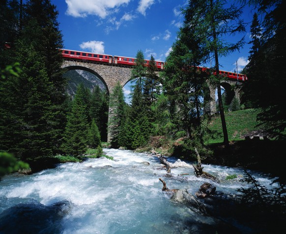 A train of the Rhaetian Railway (RhB) passes the Albulaviadukt II viaduct above Berguen in the canton of Grisons, Switzerland, pictured on June 23, 2003. Brave railway pioneers constructed the railway ...