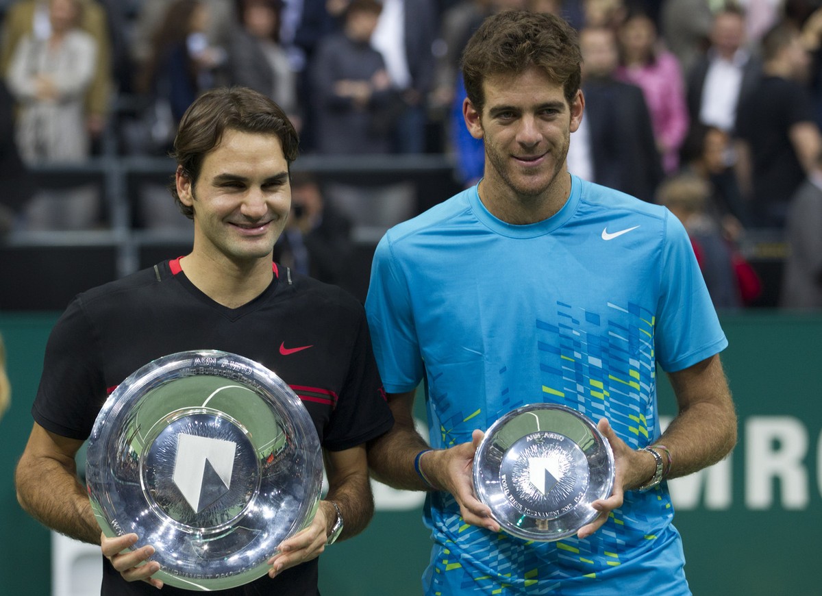 Roger Federer of Switzerland, left, and Juan Martin del Potro of Argentina hold theor trophies after the men's final at the ABN AMRO tournament at the Ahoy Arena in Rotterdam, Netherlands, Sunday ...