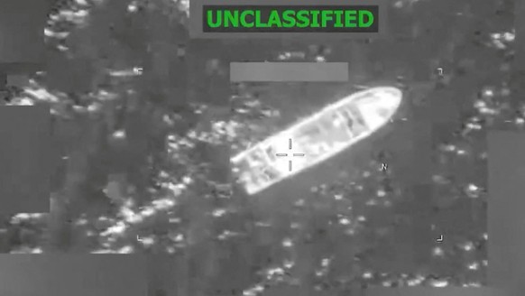 (COMBO) This combination screen grabs from a video posted on the X account of US Southern Command (SOUTHCOM) on February 20, 2026, shows a vessel before (top) and during it being struck at the directi ...
