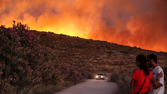 epaselect epa12213805 People look at a wildfire in the Cesme district of Izmir, Turkey, 03 July 2025. Wildfires in the Izmir region have killed two people and forced evacuations, according to Governor ...