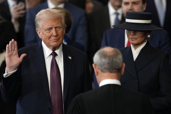 Donald Trump is sworn in as the 47th president of the United States by Chief Justice John Roberts as Melania Trump holds the Bible during the 60th Presidential Inauguration in the Rotunda of the U.S.  ...