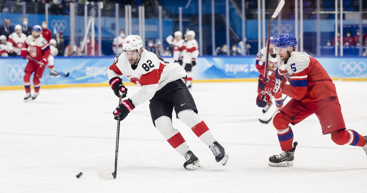 epa09748334 Jakub Jerabek (R) of the Czech Republic in action against Simon Moser (L) of Switzerland during the Men's Ice Hockey preliminary round match between Czech Republic and Switzerland at  ...