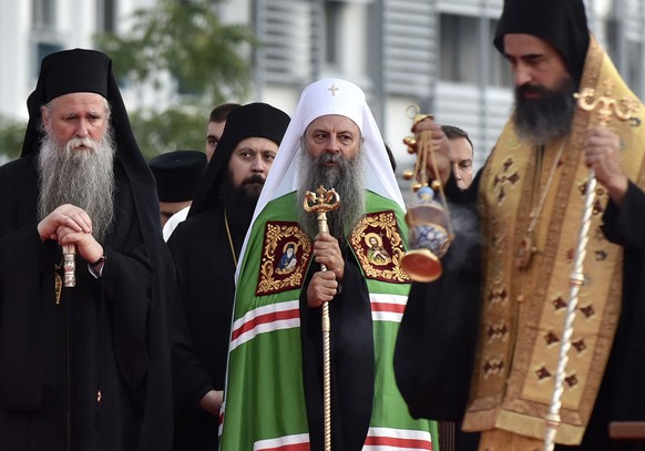 Head of the Serbian Orthodox Church, Patriarch Porfirije, center, and Mitropolitan Joanikije, left, at the arrival ceremony in front of the Serbian Orthodox Church of Christ&#039;s Resurrection in Pod ...