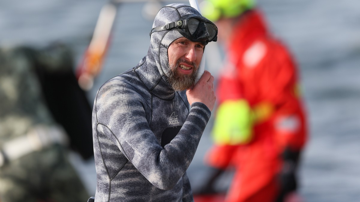epa12850227 Marine biologist Robert Marc Lehmann prepares to dive to a beached whale lying in the waters of the Baltic Sea near Niendorf harbor in Timmendorfer Strand, Germany, 26 March 2026. The hump ...