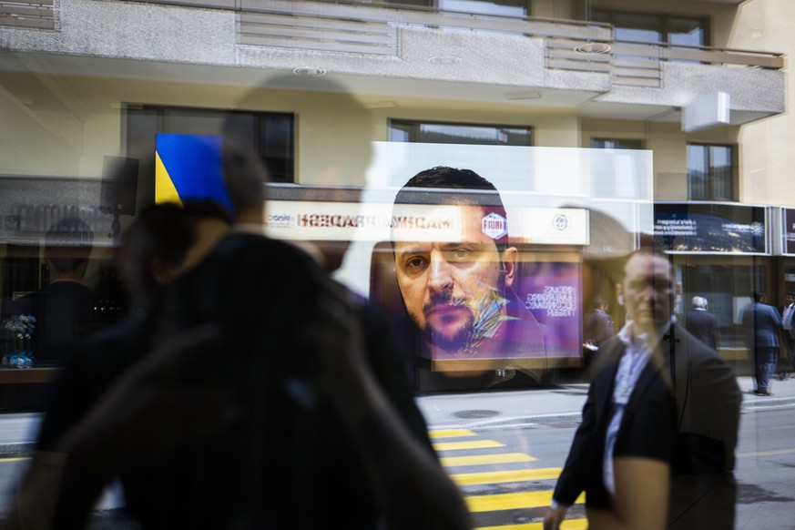 epa09965667 A video of Ukrainian president Volodymyr Zelensky is on display in the &#039;Russian Warcrimes House&#039;, with passers-by on the outside, pictured on the sideline of the 51st annual meet ...