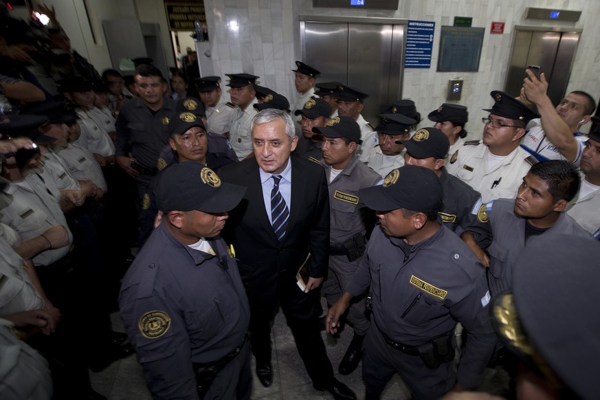 Otto Pérez Molina inmitten von Polizisten vor Gericht.<br data-editable="remove">