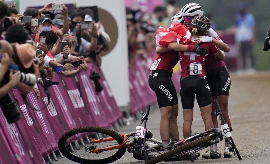 Jolanda Neff of Switzerland hugs teammates Sina Frei (8) who won silver, and Linda Indergand (19) who won bronze, for a sweep of the podium for Switzerland, at the finish line the women&#039;s cross-c ...