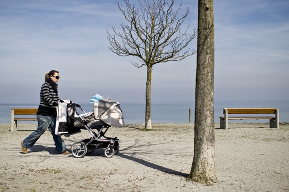 Eine Frau laeuft mit ihrem Kinderwagen der Seepromenade entlang am Dienstag, 22. Maerz 2011 am Bodensee in Horn. (KEYSTONE/Ennio Leanza)..