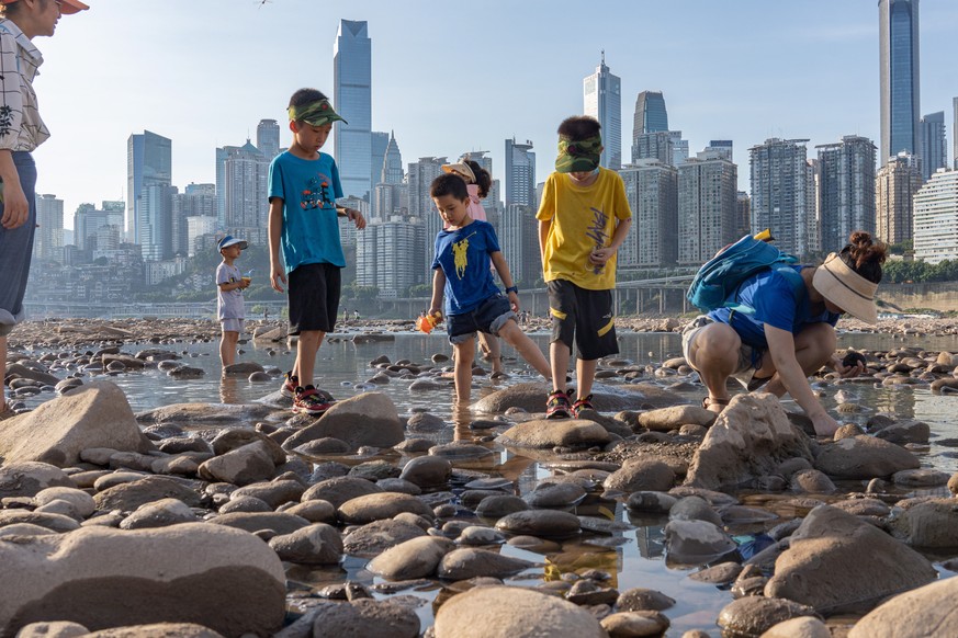 epaselect epa10131508 Children catch crabs on the dried out riverbed of the Jialing River, a major tributary of the Yangtze River, in Chongqing, China, 21 August 2022. China is experiencing its most s ...
