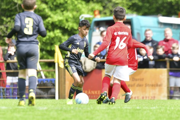 Cristiano Ronaldo junior, center, the son of Portuguese soccer player Cristiano Ronaldo, plays the ball during a junior soccer tournament for teams under the age of nine in Kempen-Toenisberg, Germany, ...