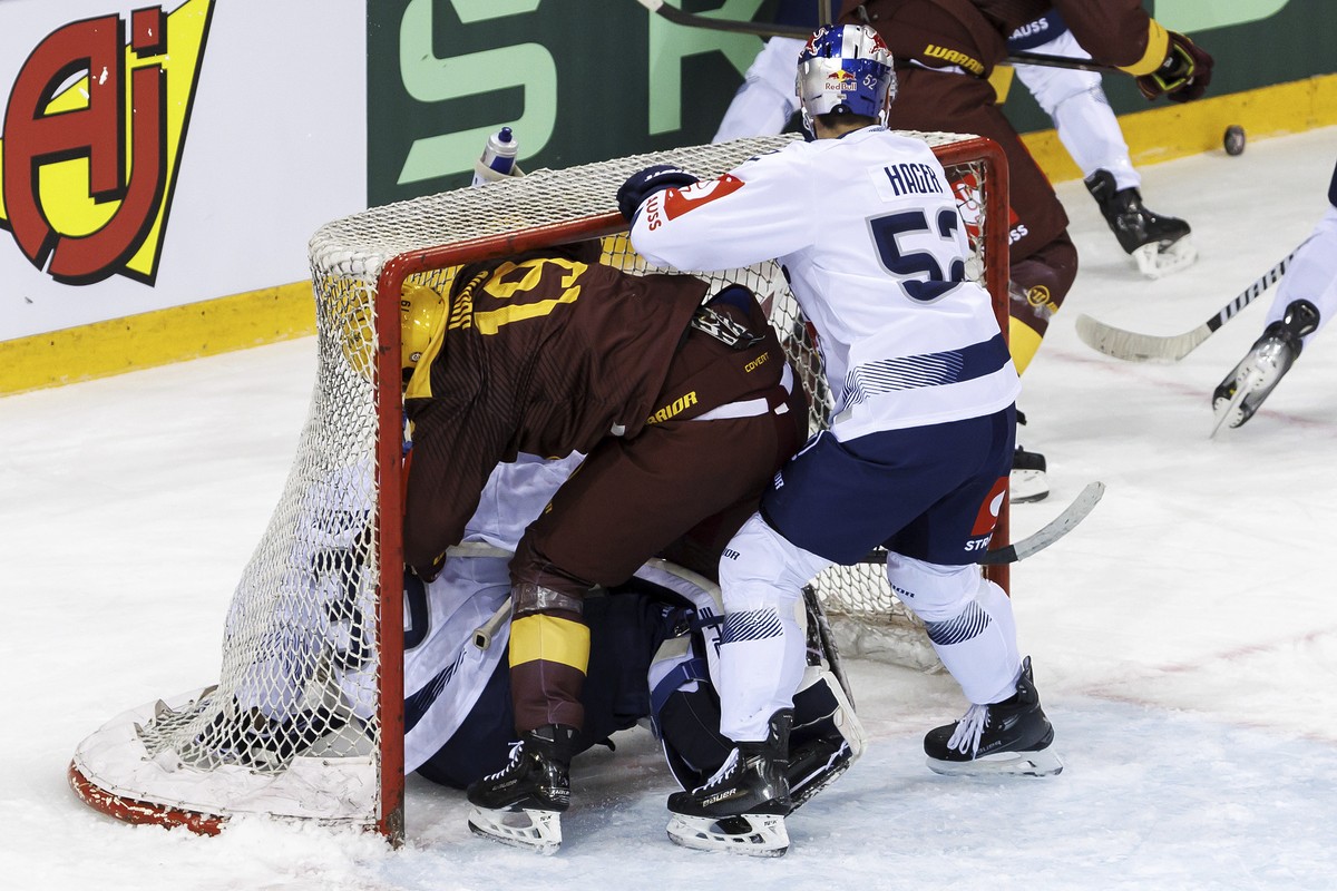 Munich's forward Patrick Hager, right, pushes Geneve-Servette's forward Josh Jooris, against Munich's goaltender Mathias Niederberger, into the net, during the Champions Hockey League R ...