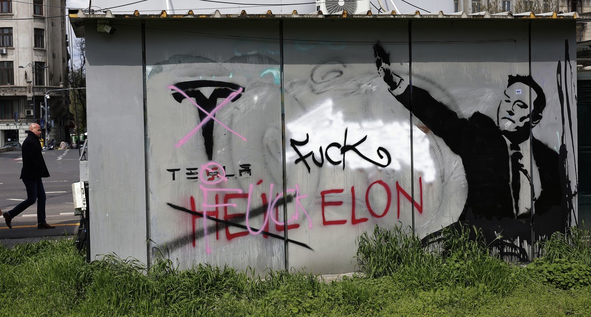 epa12015980 A man passes by a flower shop which back-wall is painted with an ani-Tesla message that also depicts Tesla founder Elon Musk making a gesture resembling with a Nazi like salute, in Buchare ...