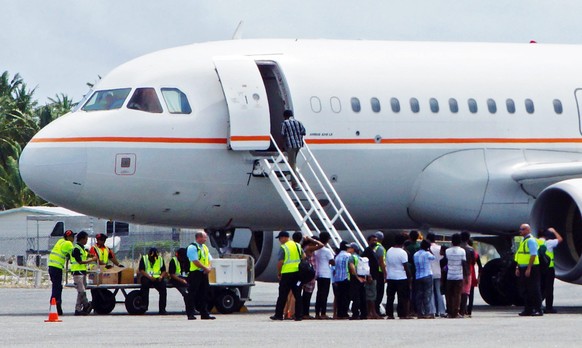 Tamilische Asylsuchende werden in Cocos Island in ein Flugzeug geleitet, das sie in ein Internierungslager bringen soll. Die Tamilen waren zuvor von der australischen Küstenwache aufgegriffen worden ( ...