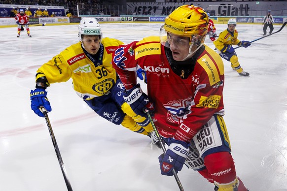 HC Davos Stuermer Simon Knak gegen EHC Kloten PostFinance Top Scorer Petteri Puhakka waehrend dem Qualifikationsspiel der Eishockey-Meisterschaft der National League zwischen den Teams EHC Kloten und  ...