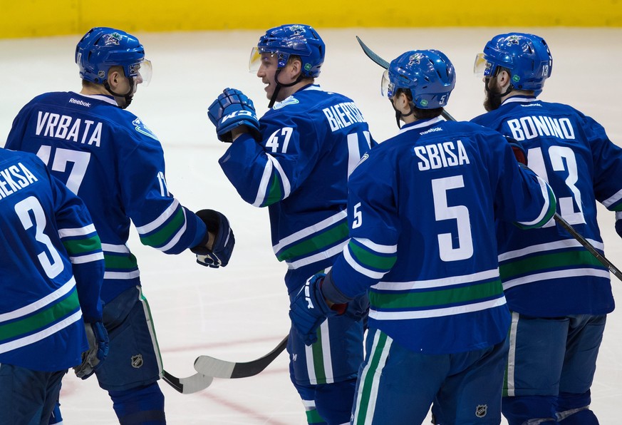 Vancouver Canucks&#039; Sven Baertschi (47), of Switzerland, celebrates his goal with teammates Radim Vrbata (17), of the Czech Republic; Luca Sbisa (5), of Switzerland; and Nick Bonino (13) during th ...