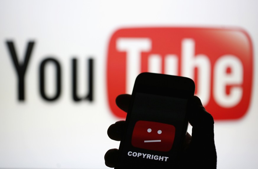 A picture illustration shows a photo taken of a YouTube error logo, displayed on a cell phone in front of a YouTube logo on an LCD screen, in central Bosnian town of Zenica, early June 18, 2014. Googl ...