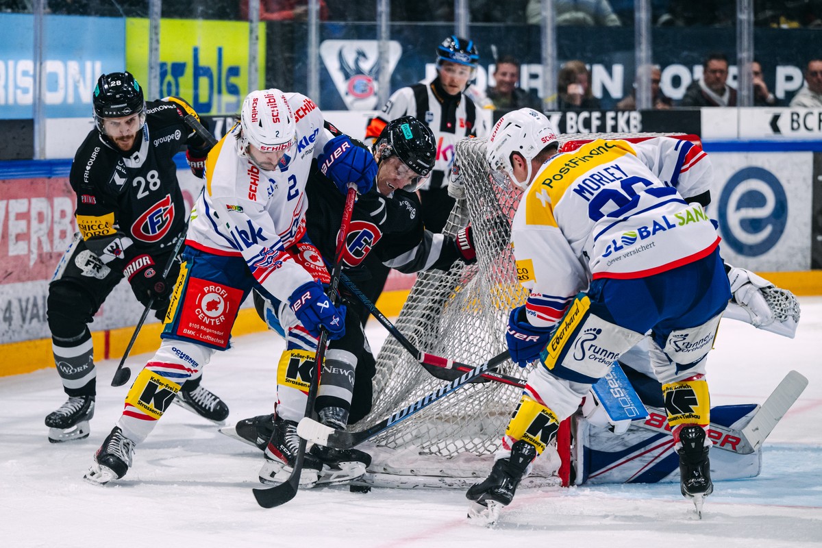 Christoph Bertschy (HCFG), gauche, lutte pour le puck avec Thomas Gregoire (EHCK), Killian Mottet (HCFG), et Tyler Morley (EHCK), droite, lors du match du championnat suisse de hockey sur glace de Nat ...