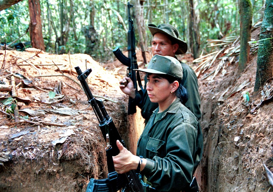 Three Colombian rebels, members of the Revolutionary Armed Forces of Colombia (FARC), take up positions in trenches around a heavily-fortified rebel camp in the southern Caqueta province December 8, 1 ...