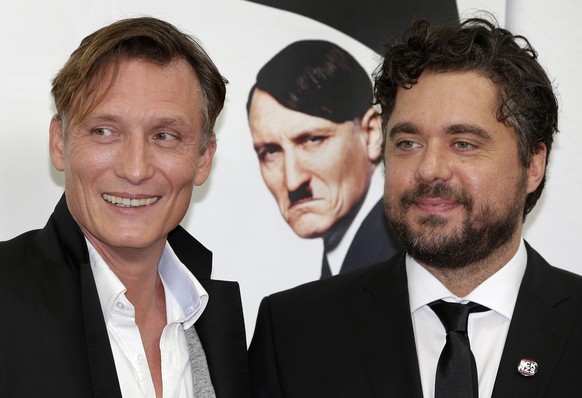 Director David Wnendt, right, and actor Oliver Masucci, left, pose for the photographers in front of a picture of Masucci as Adolf Hitler during their arrival for the world premiere of the movie &#039 ...