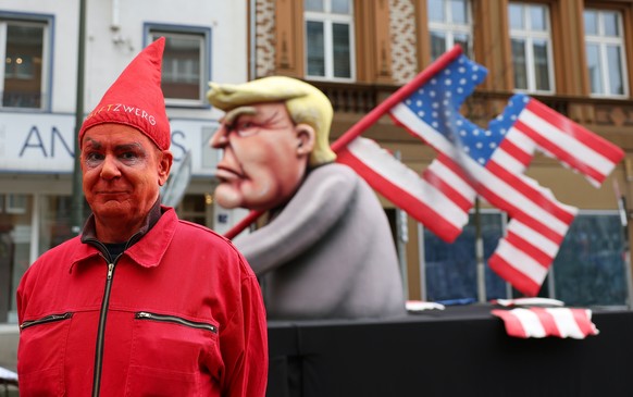 epa11147379 Jacques Tilly, artist of the socially critical floats of the Duesseldorf Rose Monday (Rosenmontag) parade, stands next to one of his carnival floats depicting Republican presidential candi ...