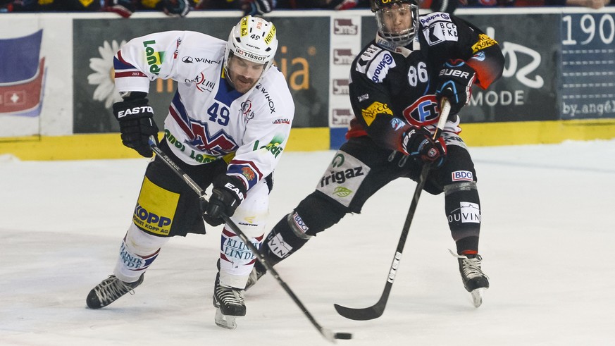 Le joueur biennois Andreas Haenni, gauche, lutte pour le puck avec le joueur fribourgeois Julien Sprunger, droite, lors du match du championnat suisse de hockey sur glace de National League A, entre l ...