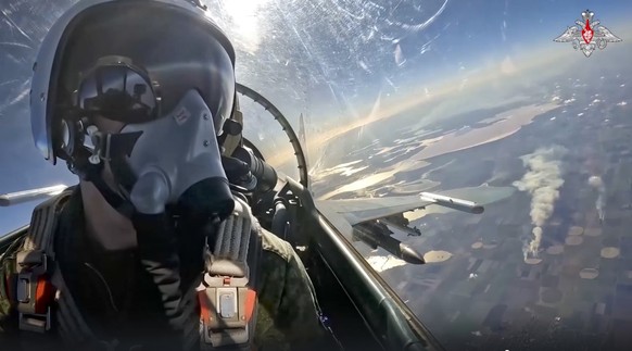 In this handout photo taken from video released by Russian Defense Ministry Press Service on Wednesday, Nov. 23, 2022, A Russian air force pilot is seen in the cockpit of his Su-35 fighter jet on a mi ...