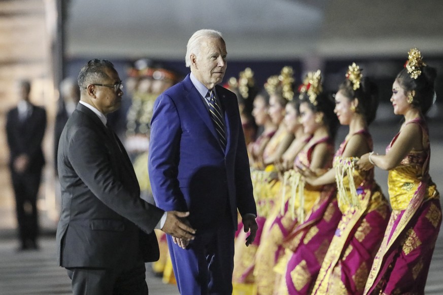U.S. President Joe Biden walks past Balinese dancers after disembarking Air Force One upon arrival to attend the G20 Summit at Ngurah Rai International Airport in Bali, Indonesia, Sunday, Nov. 13, 202 ...