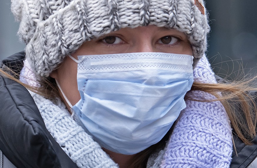 A woman is wearing a face mask as she walks through the old town in Jena, Germany, Friday, April 3, 2020. Jena becomes first German city to make wearing a face mask mandatory. Starting at the beginnin ...