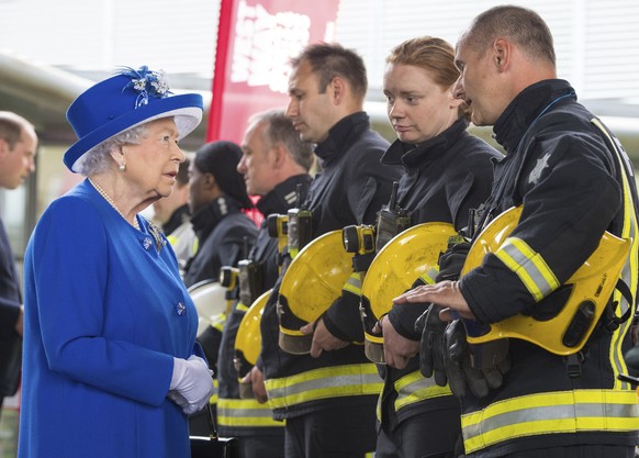 Britain&#039;s Queen Elizabeth II, left, meets firefighters during a visit to the Westway Sports Centre which is providing temporary shelter for those who have been made homeless by the fire at Grenfe ...