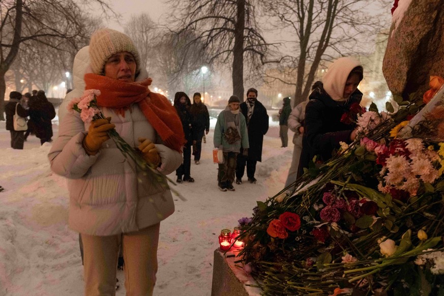 February 16, 2024, St. Petersburg, Russia: A woman holds flowers at the monuments cemeteries of victims of political repression after the death of opposition politician Alexei Navalny in St. Peters…